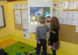 Dwoje dzieci wskazuje na mapie jeden z krajów Unii Europejskiej.